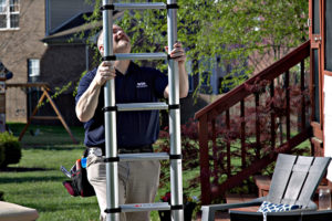 A WIN Home Inspection franchise owner sets up a metal ladder against an enclosed patio.