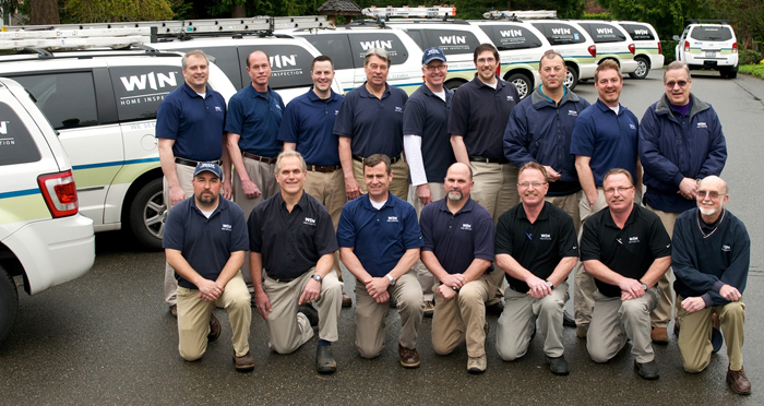 group of WIN home inspectors in parking lot with WIN vans