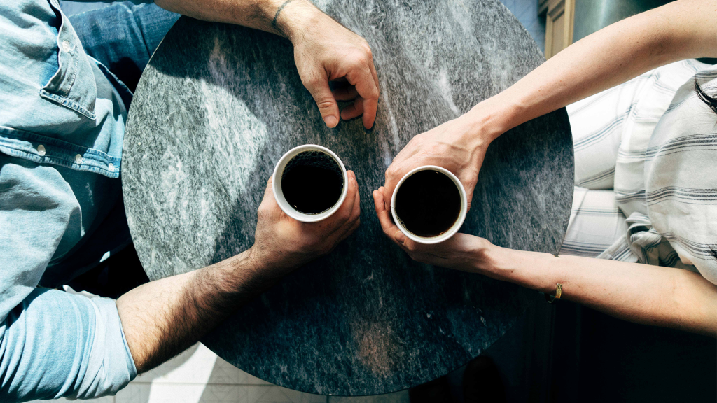Two people having coffee at table