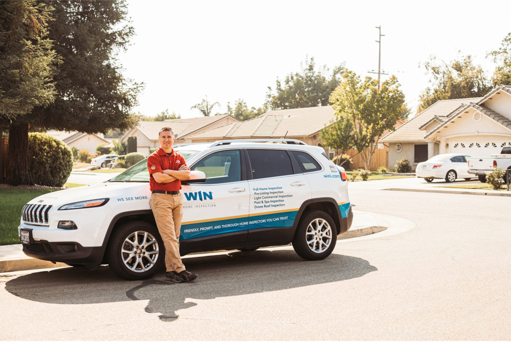WIN Franchise owner standing with WIN branded vehicle