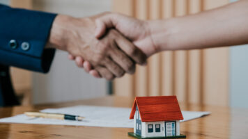 Estate agent shaking hands with his customer after contract sign