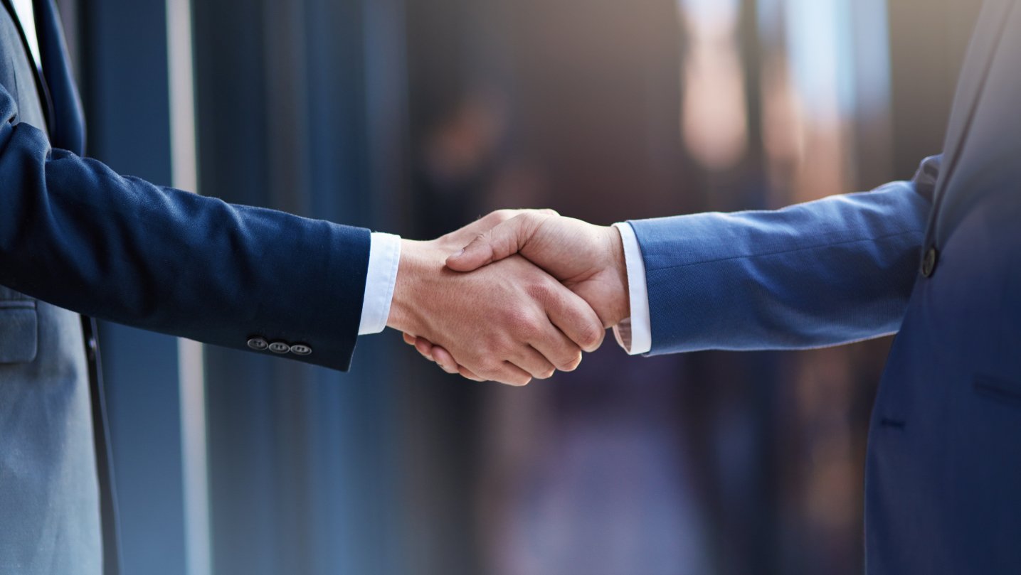 a close-up of two businessman shaking hands