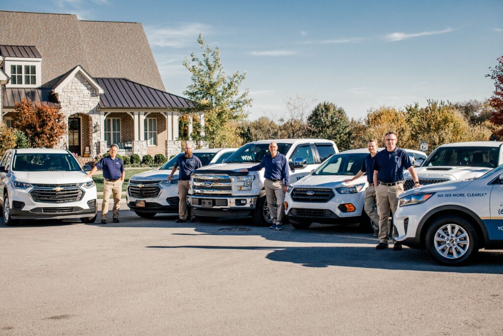 WIN Home Inspectors posing with their vehicles